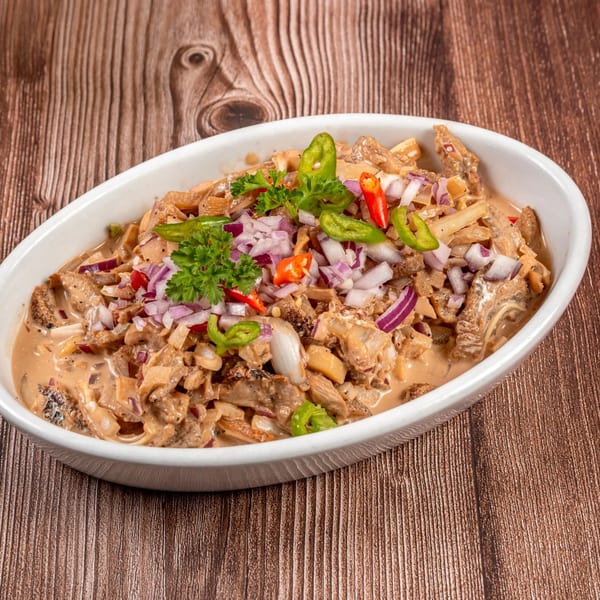 Filipino Bopis, a dish with minced pork and lungs in a creamy sauce, garnished with chilies and onions.
